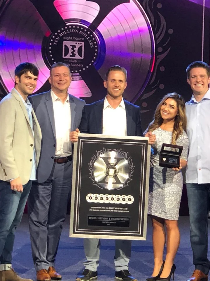 Bryan and Stephanie Dulaney on stage with a Two Comma Club X award
