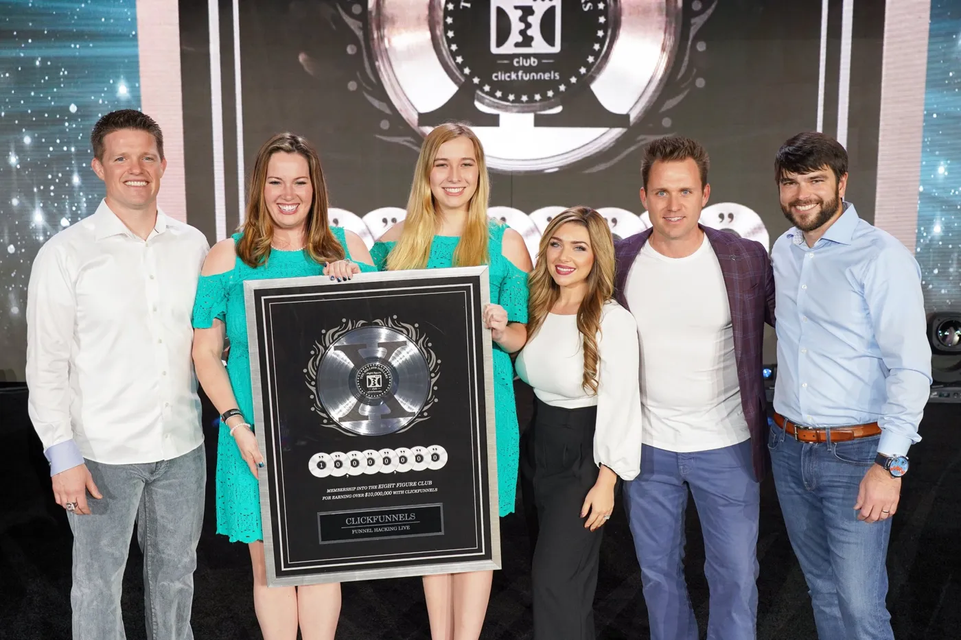 Bryan and Stephanie Dulaney on stage with clients receiving a Two Comma Club X award