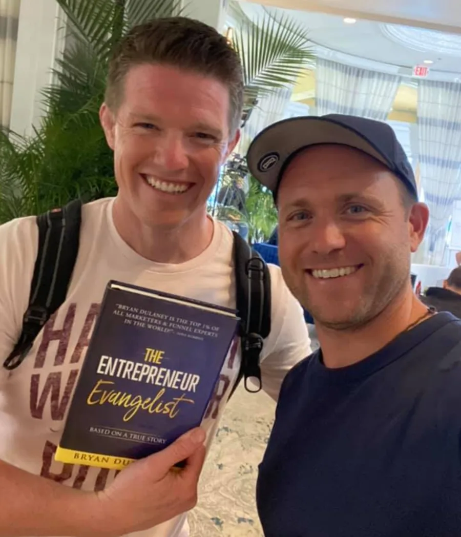 Russell Brunson holding The Entrepreneur Evangelist with Bryan Dulaney